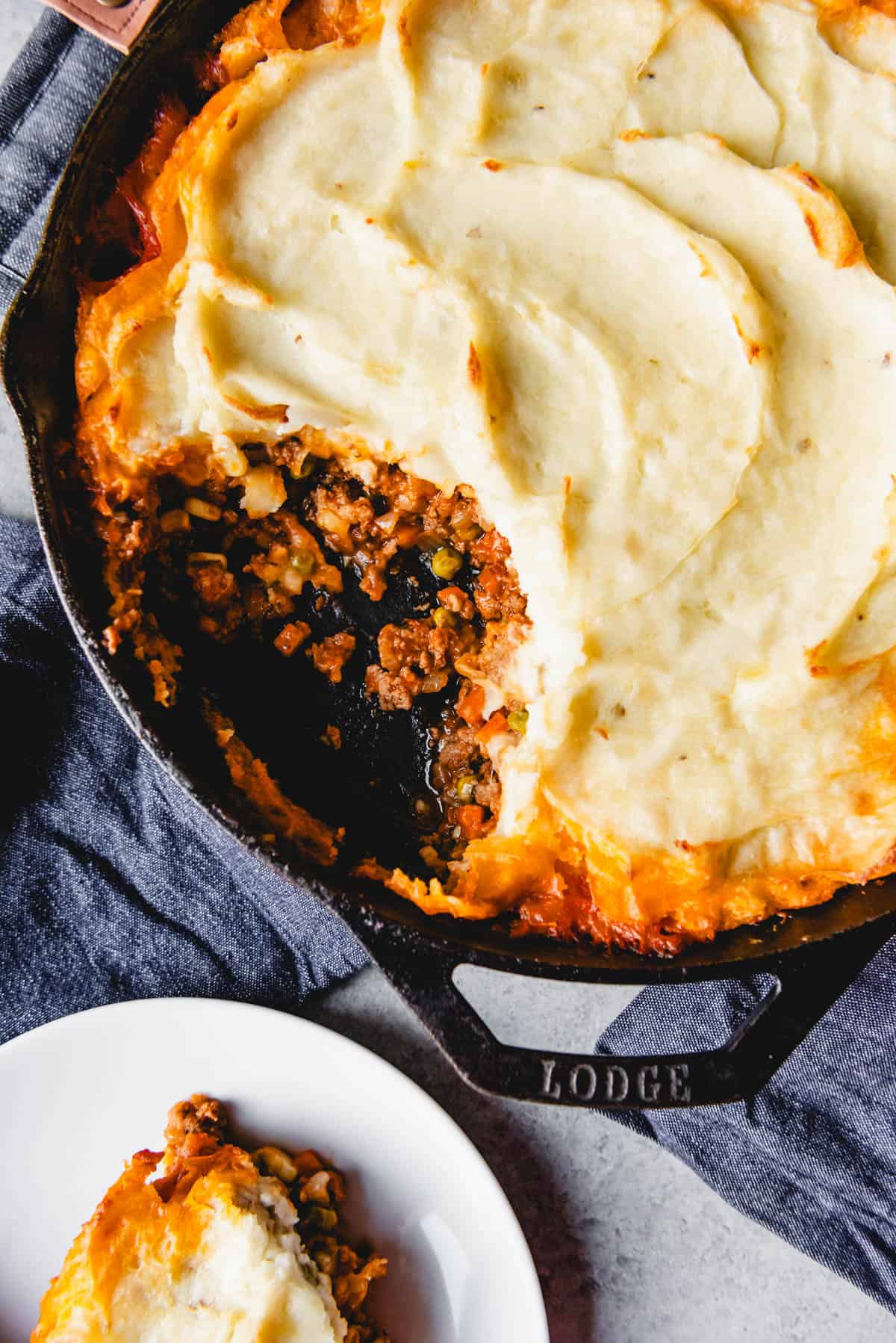 An image of classic shepherd's pie, a traditional Irish recipe, made with ground lamb, vegetables, a rich gravy, and creamy mashed potatoes on top.