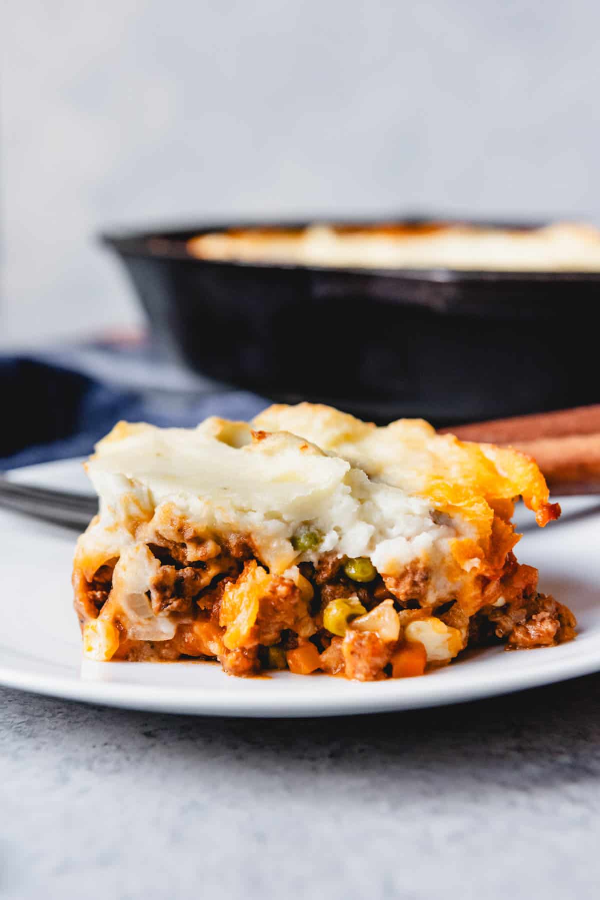 An image of a serving of authentic shepherd's pie made with lamb, vegetables, and mashed potatoes on a plate.