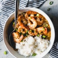 shrimp etouffee in a bowl with white rice and a spoon