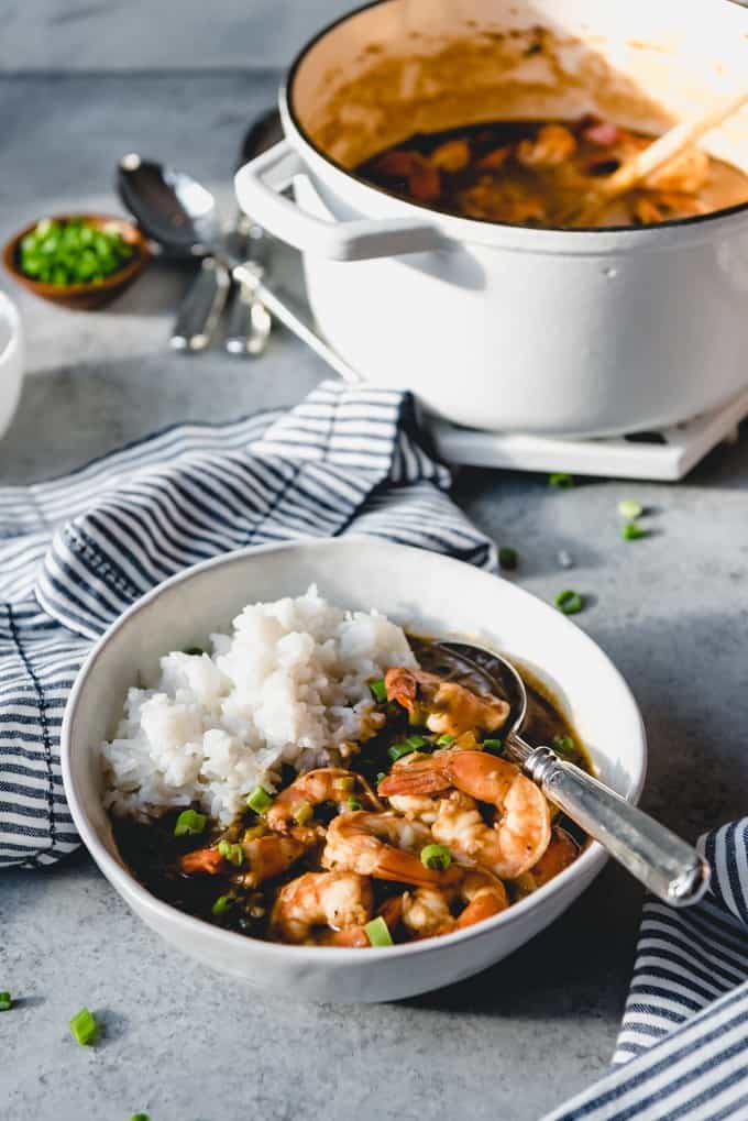 An image of a bowl of shrimp etouffee served with white rice in a bowl.