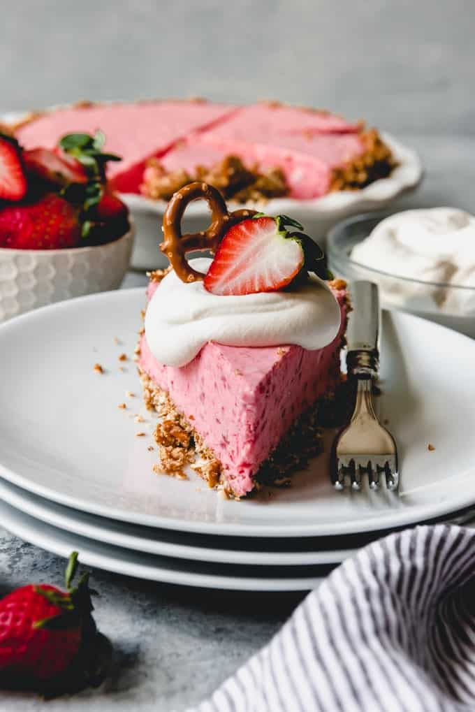 a slice of Strawberry Pretzel Icebox Pie on a white plate with a fork to the side