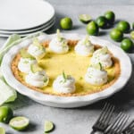 An image of a classic key lime pie topped with whipped cream swirls.