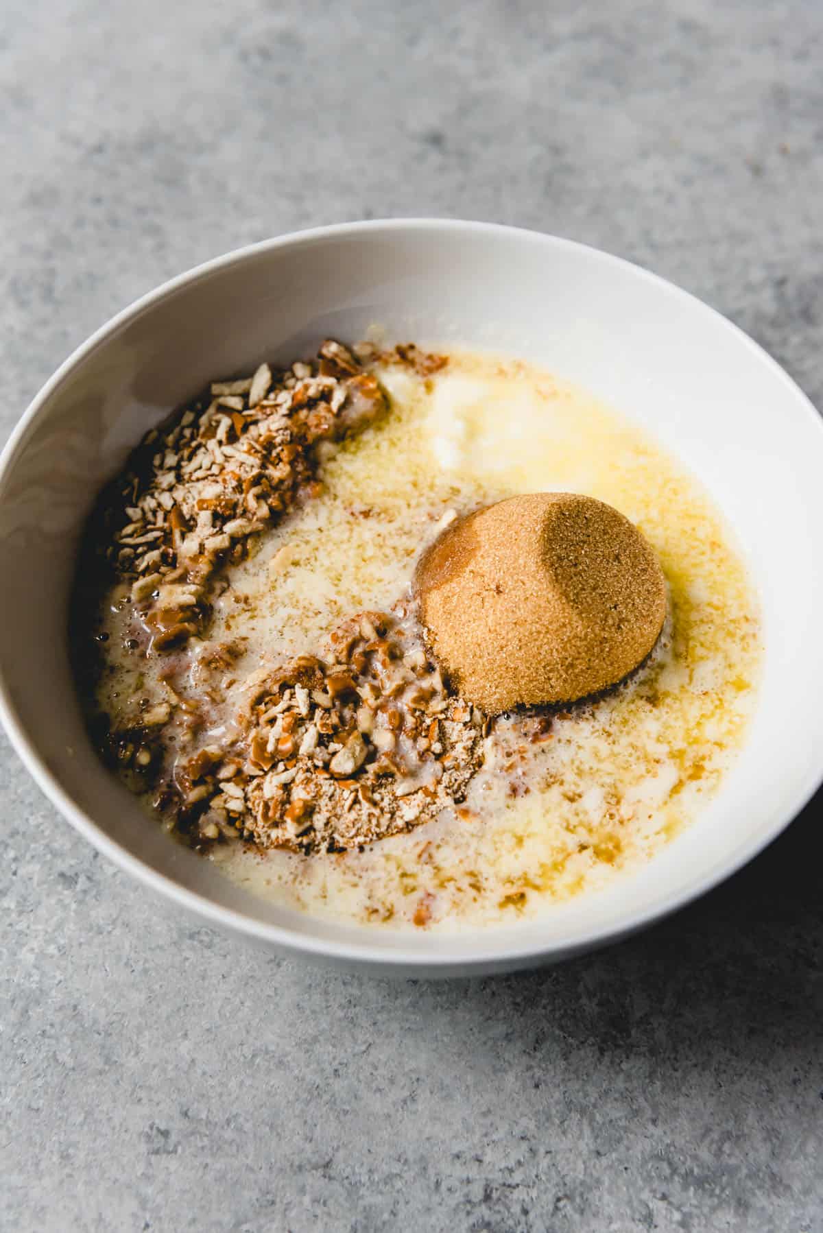 Combining brown sugar, melted butter, and crushed pretzels in a bowl.