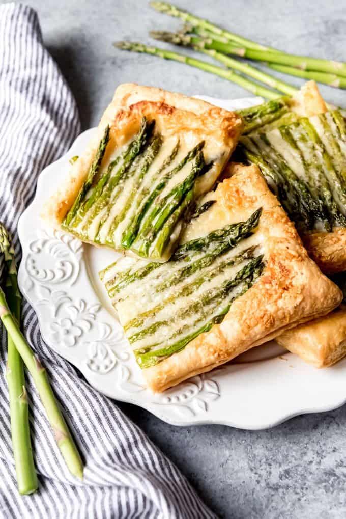 An image of asparagus on puff pastry on a white plate.