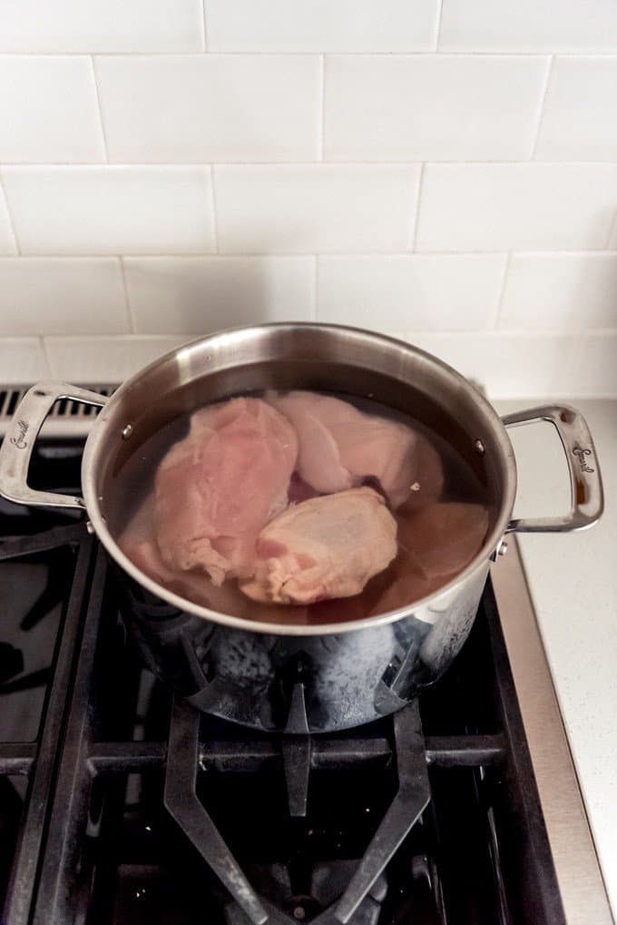 An image of chicken pieces in water to boil on the stove.
