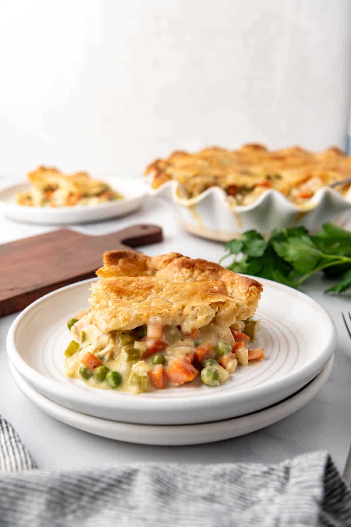 A slice of chicken pot pie on a white plate.