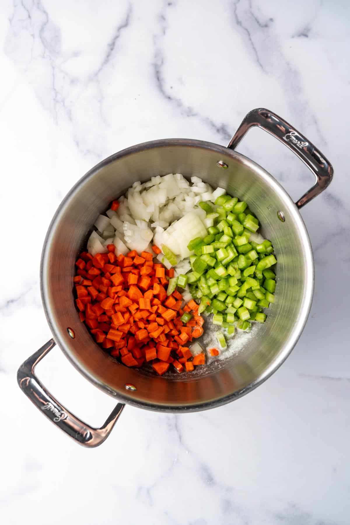 Diced carrots, onions, and celery in a large pot.