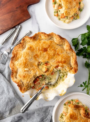 An overhead image of a chicken pot pie with some servings removed from it.