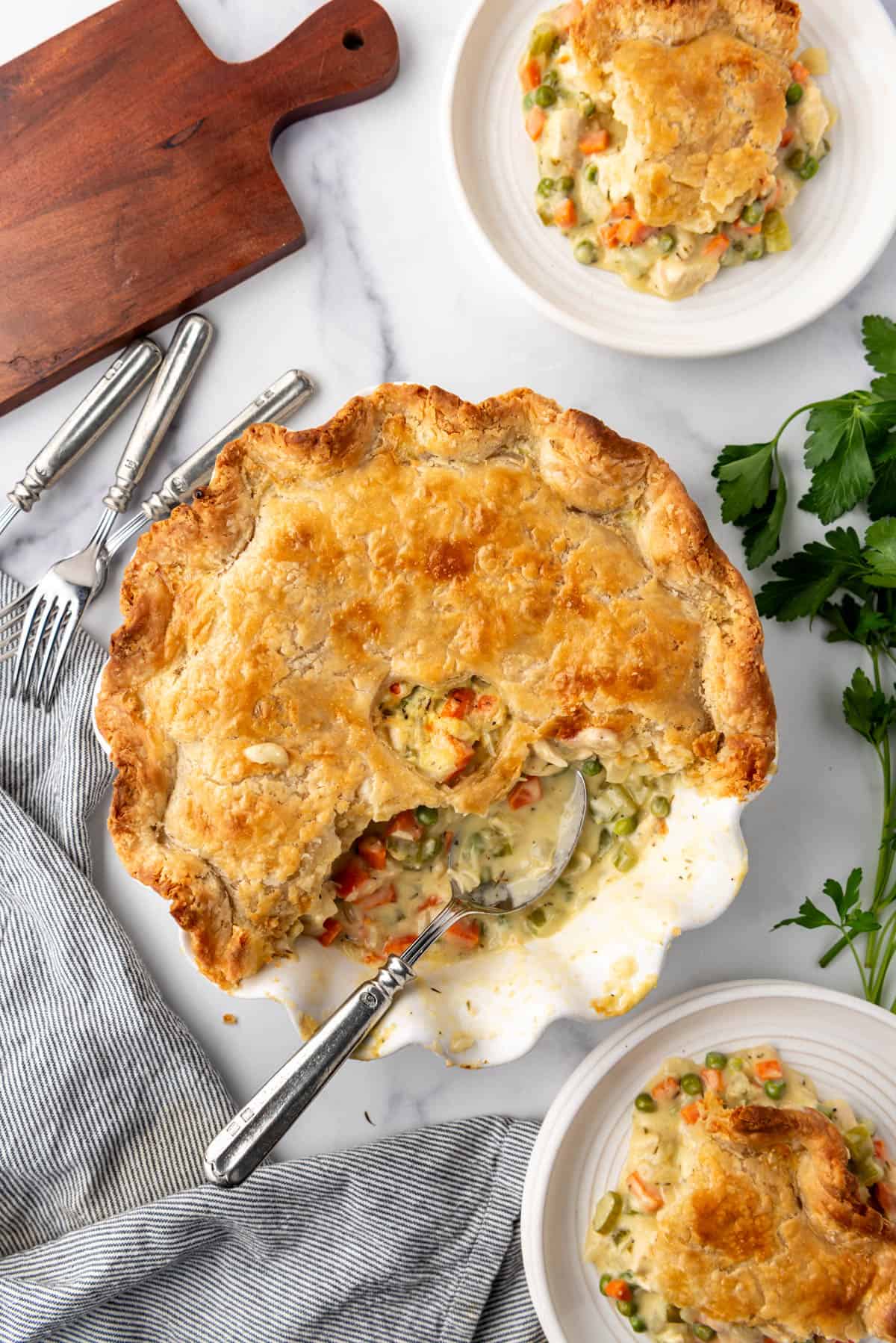 An overhead image of a chicken pot pie with some servings removed from it.