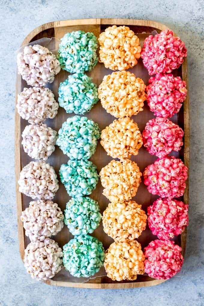 An image of jello popcorn balls in rows in rainbow colors.