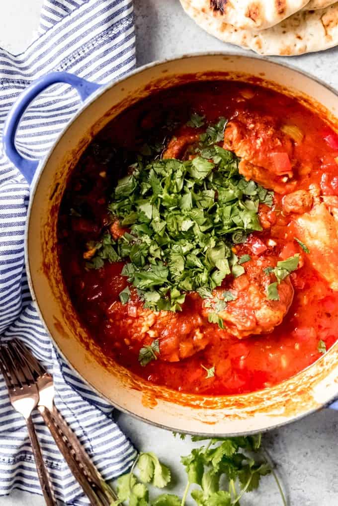 An aerial view of Georgian Chicken Stew with Tomatoes and Herbs in a dutch oven.