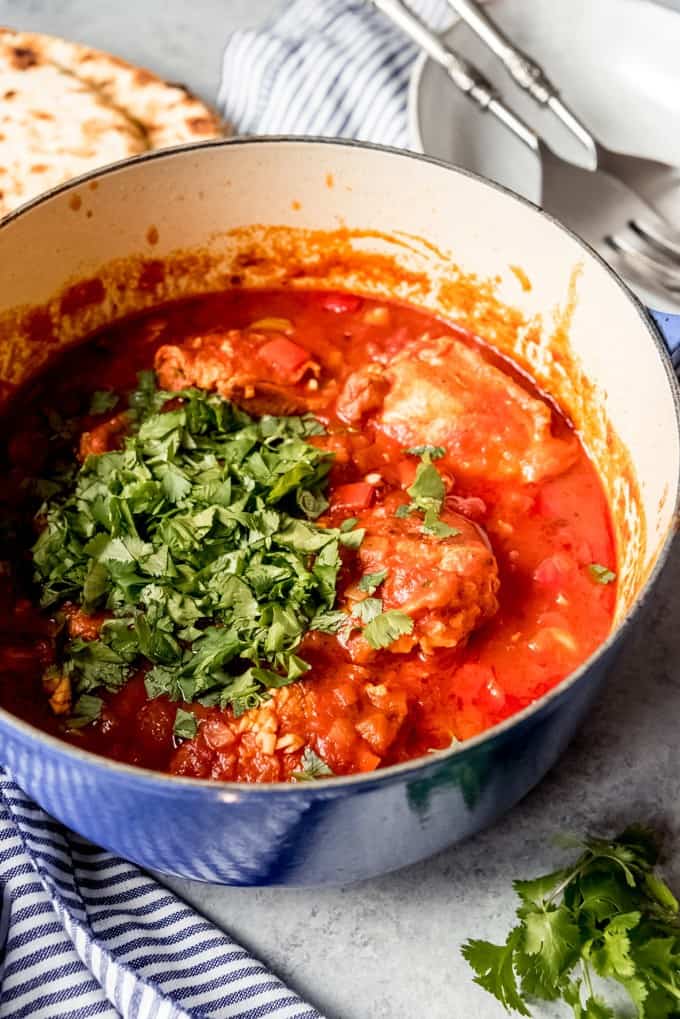 An image of chakhokhbili in a dutch oven with fresh cilantro sprinkled over the top.
