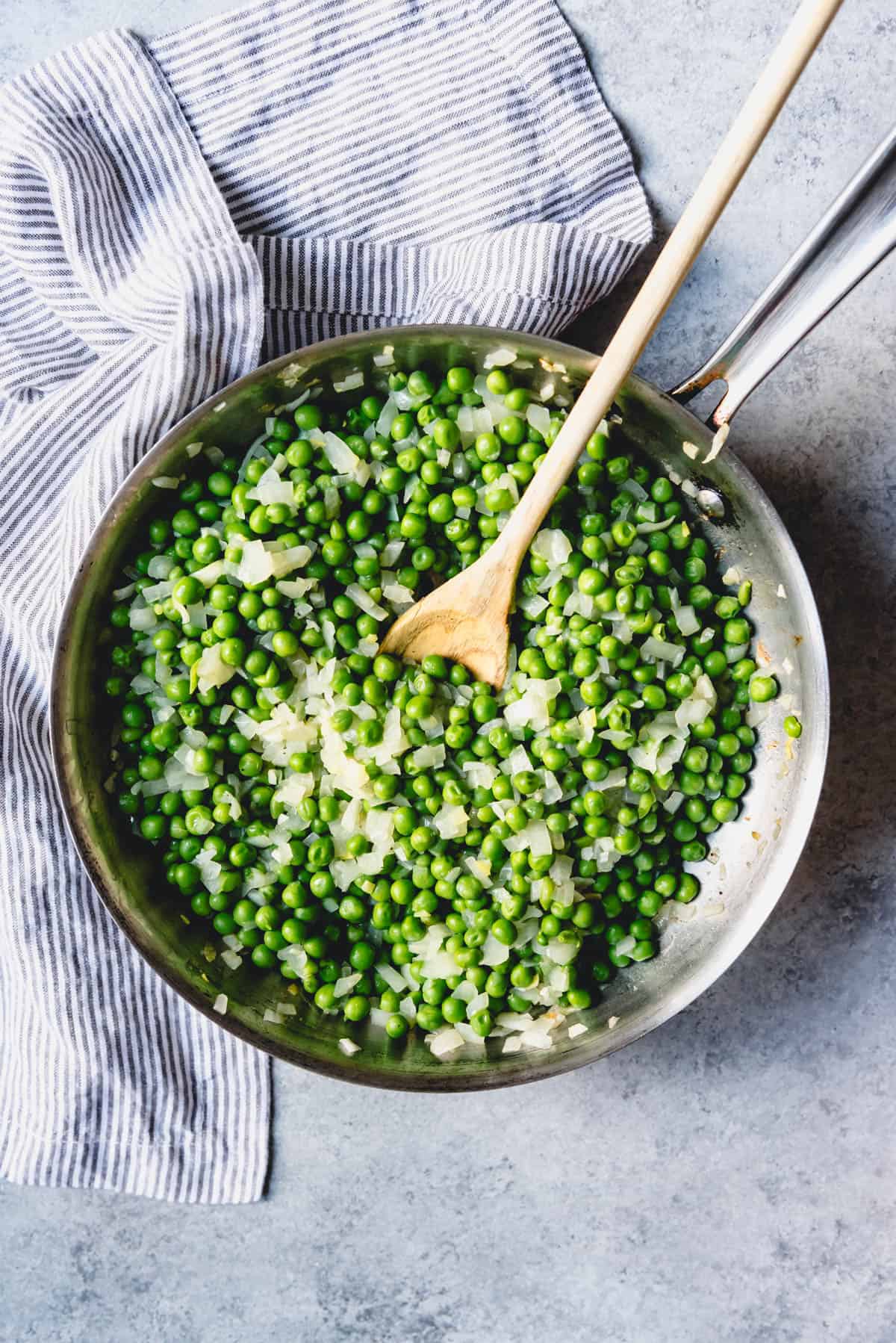 An image sauteed peas and onions for an easy veggie side dish.