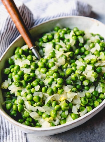 A bowl filled with peas and onions.
