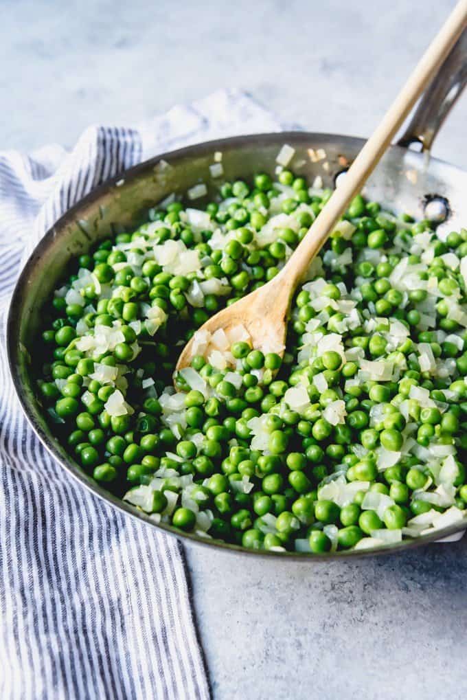 An image of a pan of peas and onions for an easy vegetable side dish.