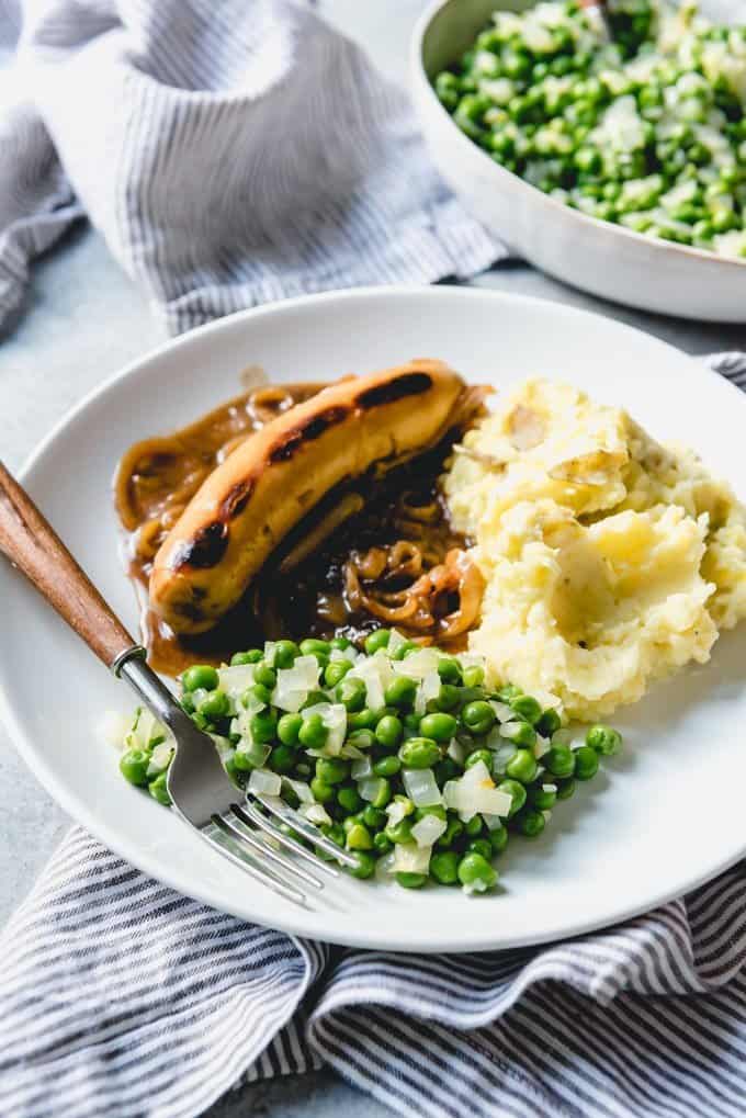 An image of peas with bangers and mash.