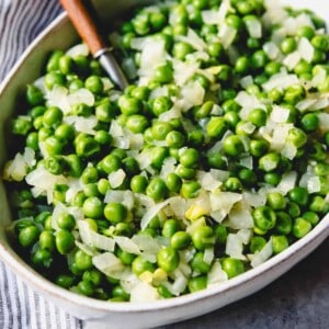 A bowl filled with peas and onions.