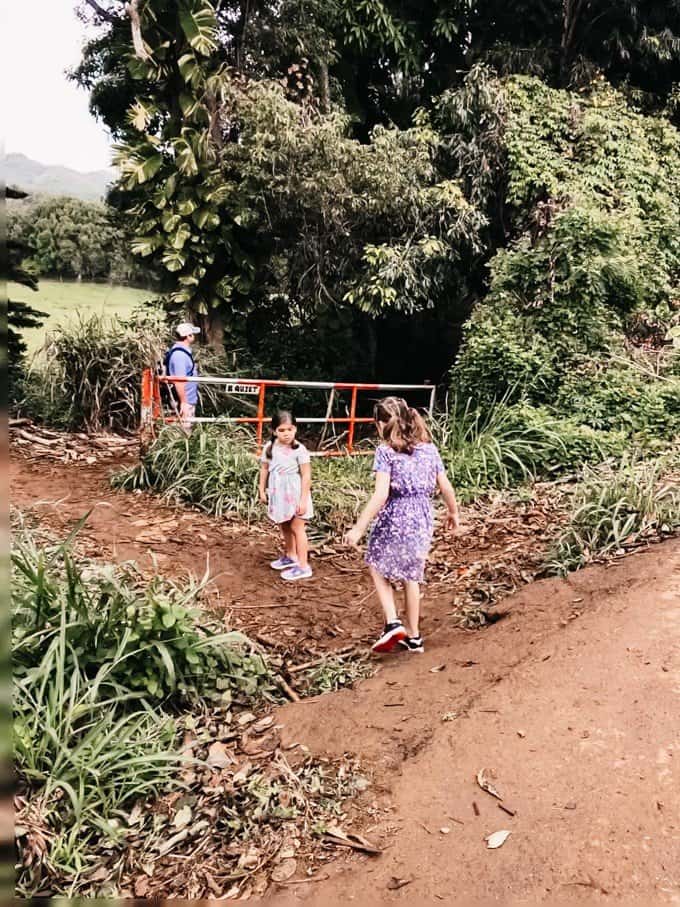 two girls walking on a dirt path