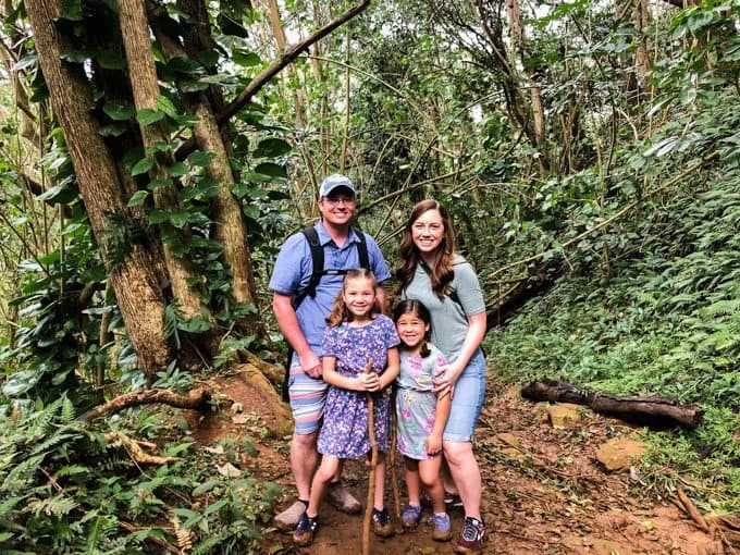 a family of 4 posing for a photo on a hiking trail