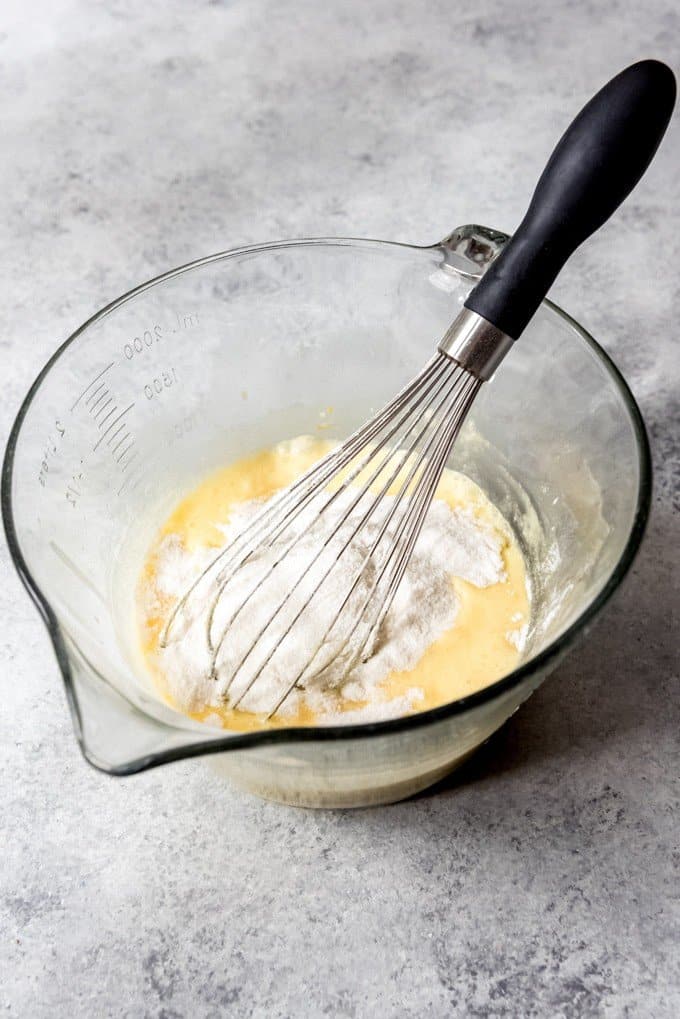 An image of lemon cake batter ingredients being whisked together in a bowl.