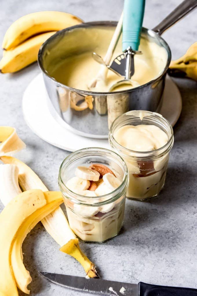An image of jars filled with homemade pudding, sliced ripe bananas, and Nilla wafers for Southern Banana Pudding.
