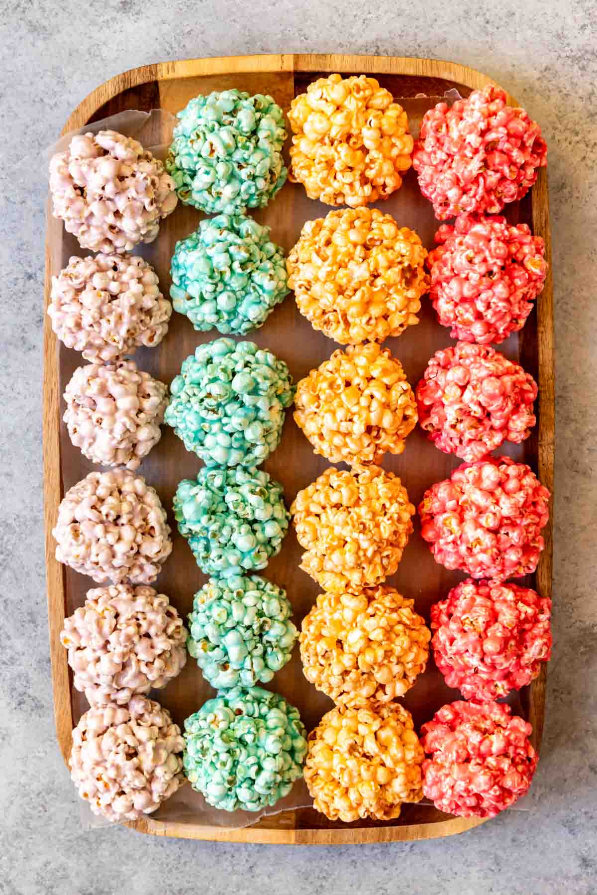 An image of jello popcorn balls in rows in rainbow colors.