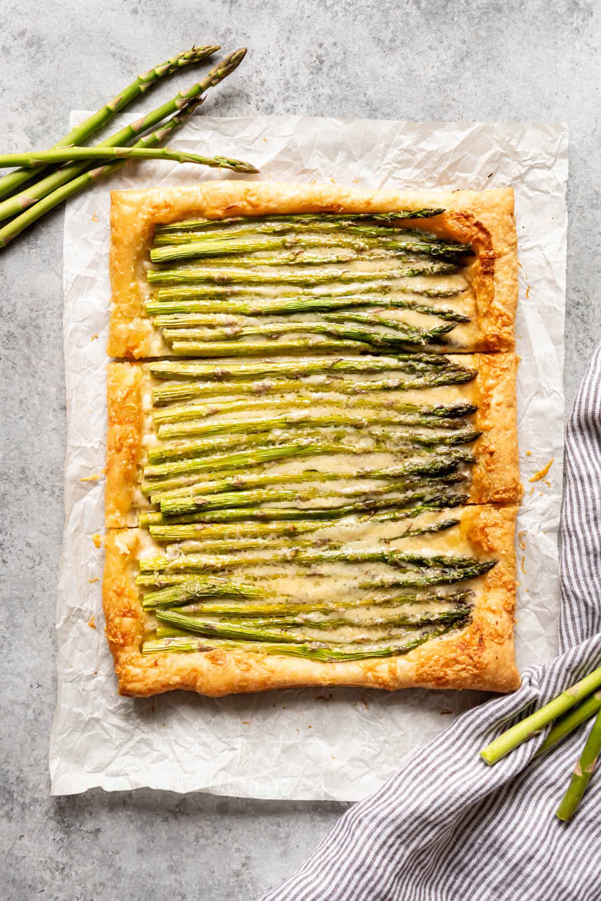 An aerial view of asparagus tart sliced into three parts.