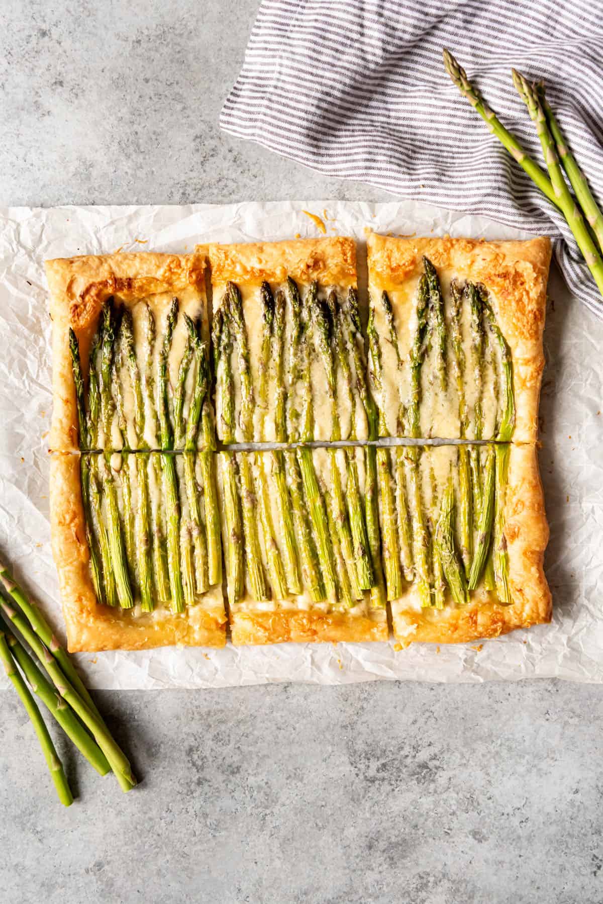 An image of an easy spring asparagus tart cut into squares.