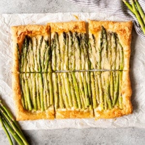 An image of an easy spring asparagus tart cut into squares.