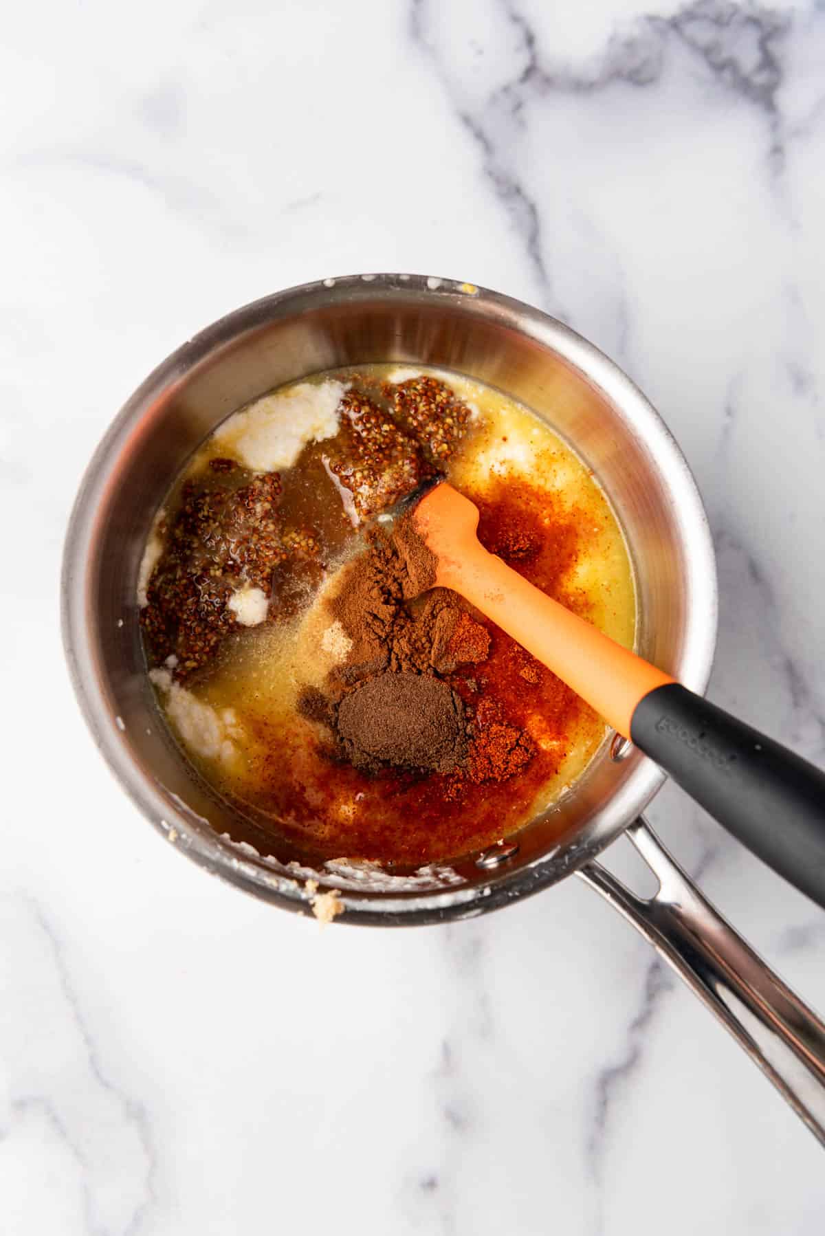 Combining ingredients to make a brown sugar ham glaze in a saucepan.