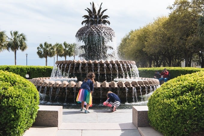 An image of two children playing at the Pineapple Fountain in Waterfront Park in Charleston, South Carolina.