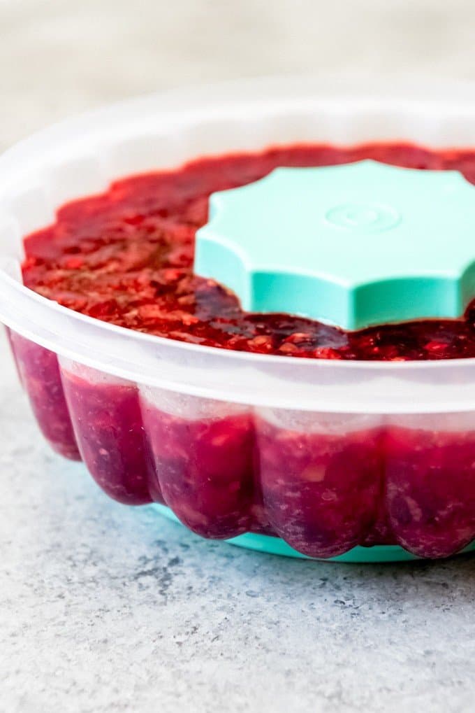 An image of a cherry jello with fruit in a jello mold.