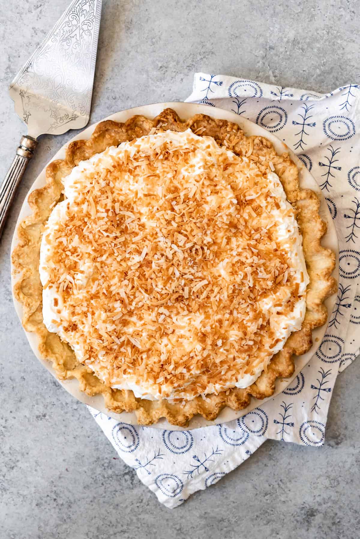 An image of a homemade coconut cream pie made from scratch, covered in toasted coconut.