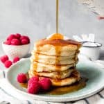 a stack of hoecakes topped with syrup and garnished with fresh berries