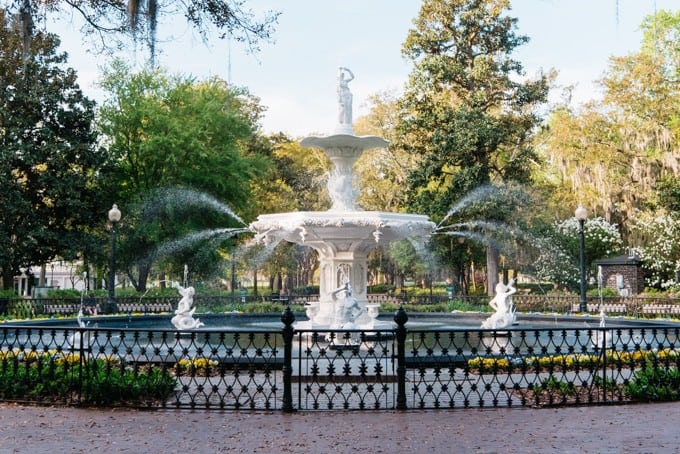 An image of a white fountain surrounded by wrought iron.
