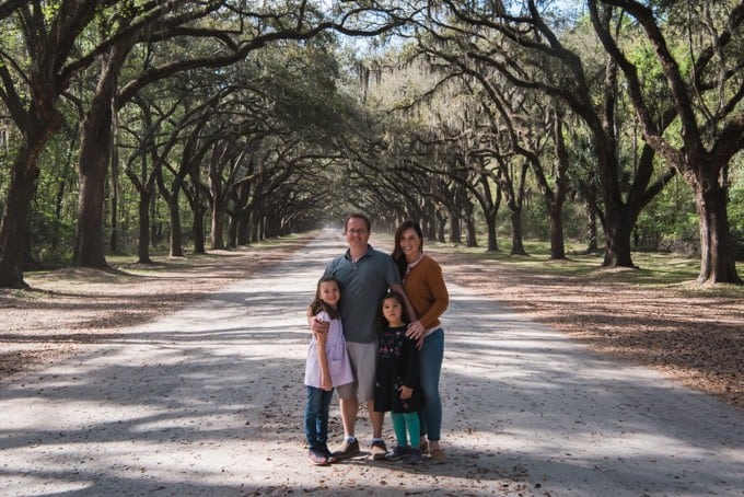 An image of a family in front of the live oak avenue at Wormsloe Historic Site in Savannah, Georgia.