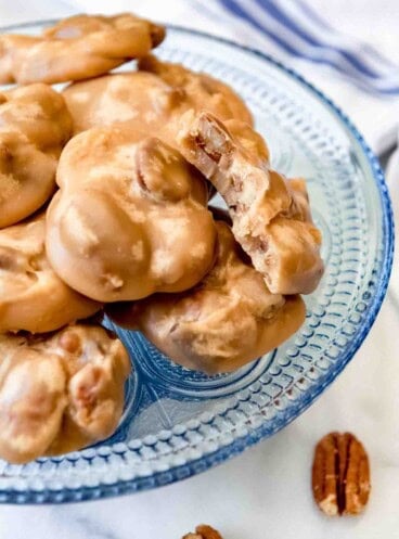 An image of pecan praline candy on a blue glass plate.