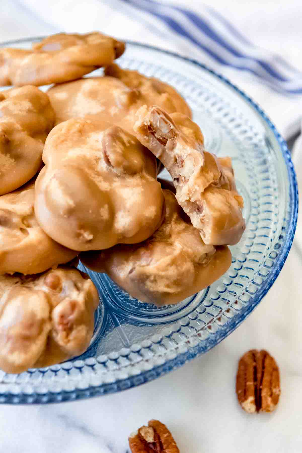 An image of pecan praline candy on a blue glass plate.