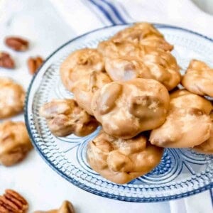 An image of pecan praline candy on a blue glass plate.