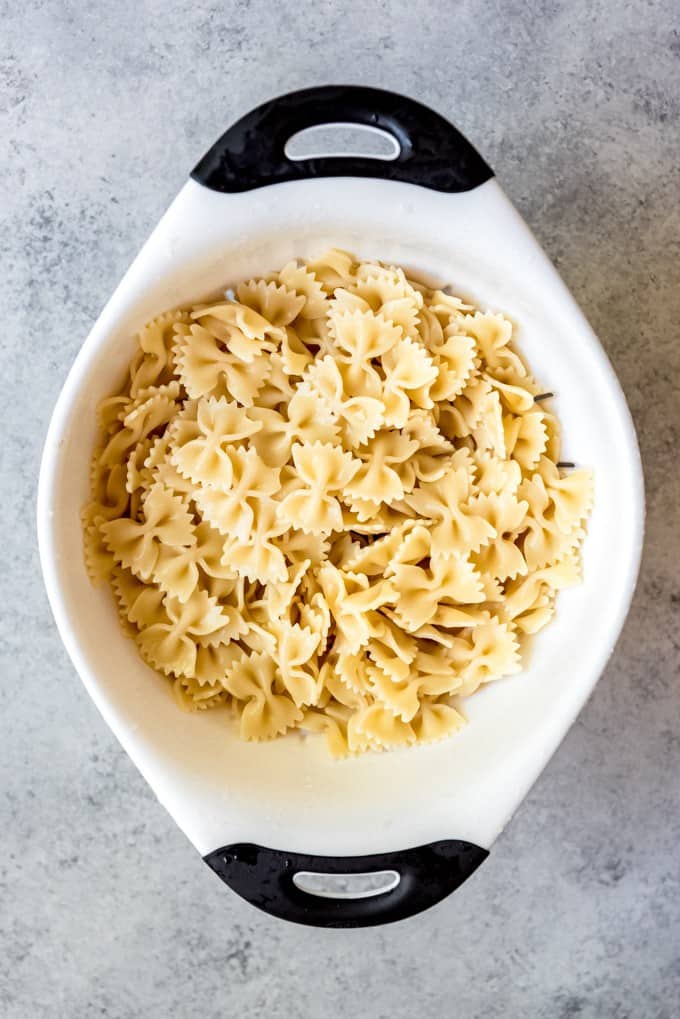 An image of cooked bow tie pasta in a strainer.