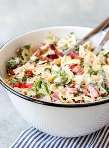 A large bowl of an easy pasta salad with tomatoes, lettuce, bacon, and bowtie pasta.