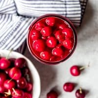Fresh cherry pie filling next to a bowl of cherries.
