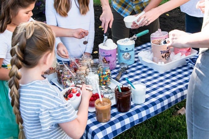An image of a bunch of toppings on a table for people to make their own ice cream sundaes.