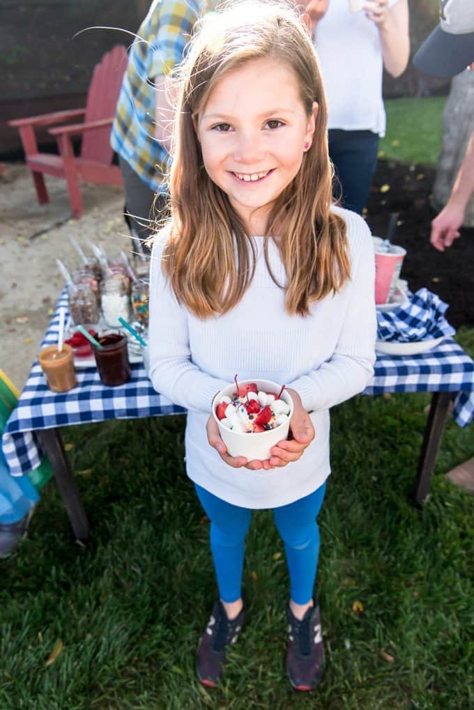 An image of girl holding an ice cream sundae.