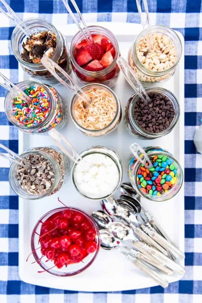 An image of mason jars filled with ice cream sundae toppings.