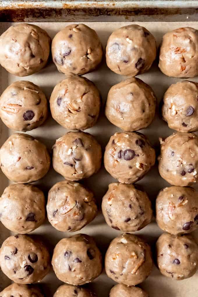 An image of balls of chocolate chip cookie dough with pecans ready to be frozen then baked later.