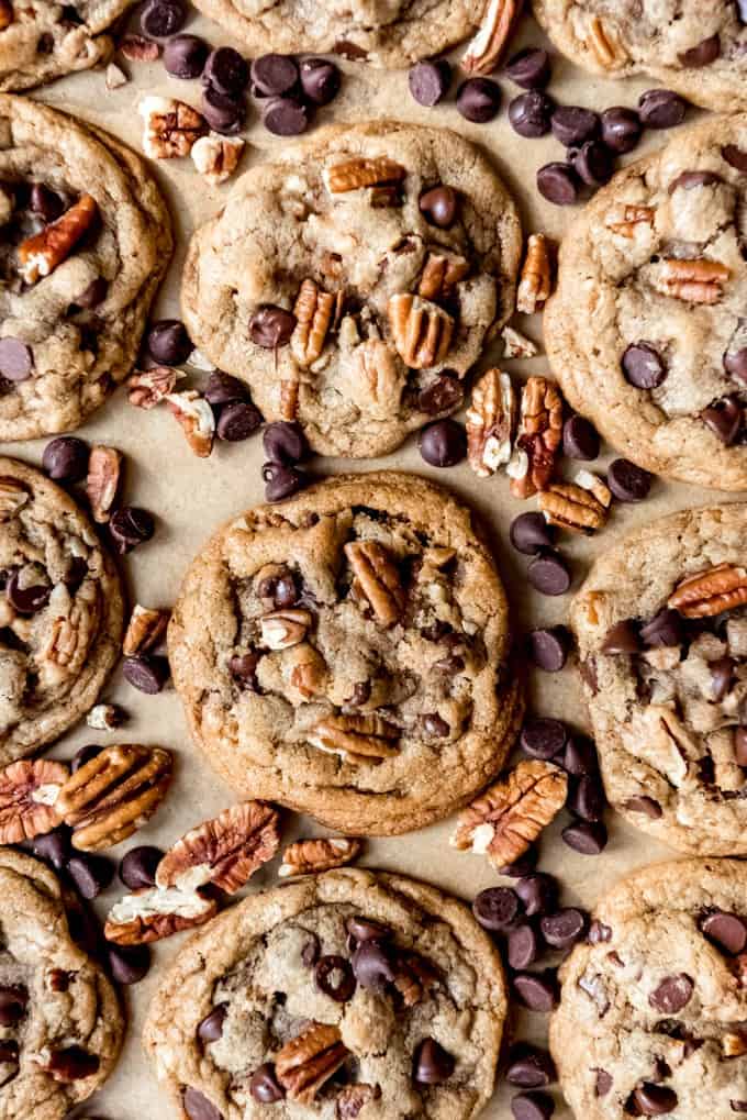 An image of chocolate chip cookies with pecans on a baking sheet.