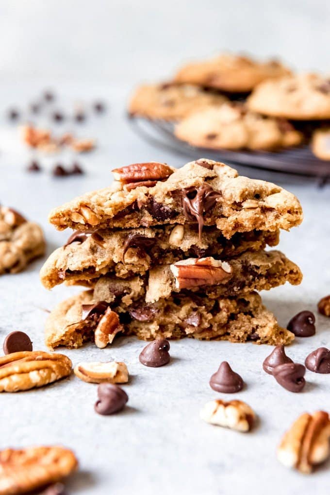 An image of pecan chocolate chip cookies stacked on top of each other.