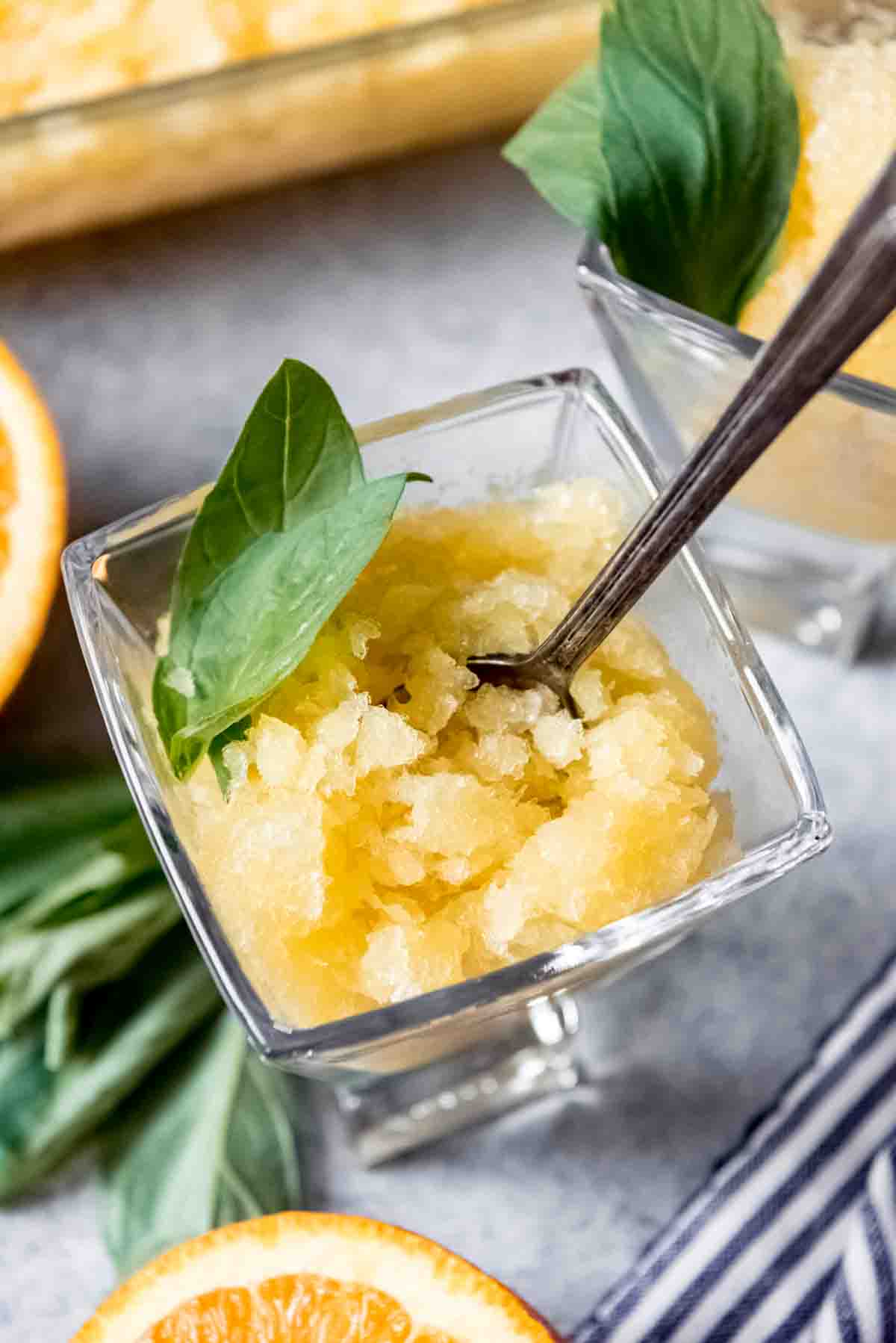 An image of a orange basil granita in a glass.