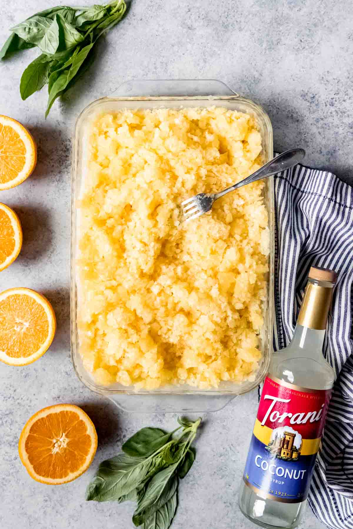 An image of a large pan of orange basil coconut granita.